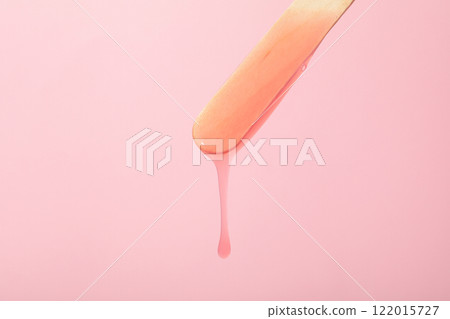 A wooden stick for depilation on a pink background 122015727