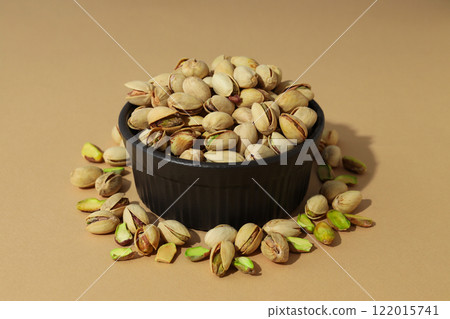 Pistachios in a plate, on a beige background. 122015741