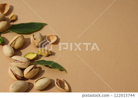 Pistachios in a plate, on a beige background. 122015744