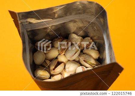 Pistachios in a craft bag, on a yellow background. Pistachios in a craft bag, on a yellow background. 122015746