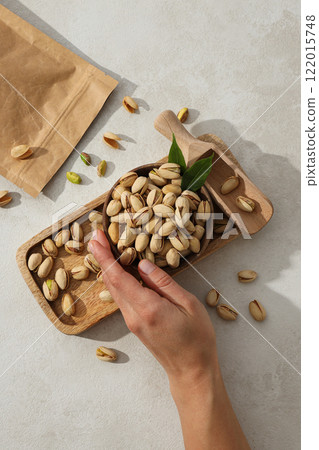 Pistachios in a craft bag, on a yellow background. Pistachios in a craft bag, on a yellow background. 122015748