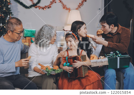 Portrait of Asian family exchanging presents during christmas at home. Attractive happy people holding gift box, celebrate holiday thanksgiving, xmas eve tradition in living room in house together. Portrait of Asian family exchanging presents during christmas at home. Attractive happy people holding gift box, celebrate holiday thanksgiving, xmas eve tradition in living room in house together. 122015854