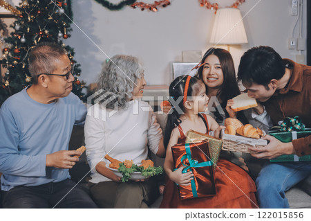 Portrait of Asian family exchanging presents during christmas at home. Attractive happy people holding gift box, celebrate holiday thanksgiving, xmas eve tradition in living room in house together. Portrait of Asian family exchanging presents during christmas at home. Attractive happy people holding gift box, celebrate holiday thanksgiving, xmas eve tradition in living room in house together. 122015856