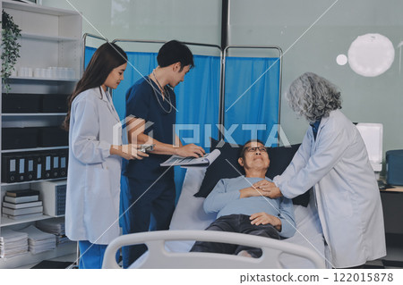 A team of doctors and nurses are working to treat a female patient in the patient's room. A team of doctors and nurses are working to treat a female patient in the patient's room. 122015878