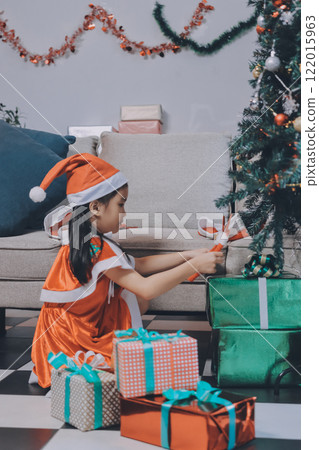 Christmas holidays concept. Happy magic little girl opens a gift box. Child is happy with a New Year's gift. The background is Christmas tree. The concept of Christmas and New Year. High quality photo Christmas holidays concept. Happy magic little girl opens a gift box. Child is happy with a New Year's gift. The background is Christmas tree. The concept of Christmas and New Year. High quality photo 122015963