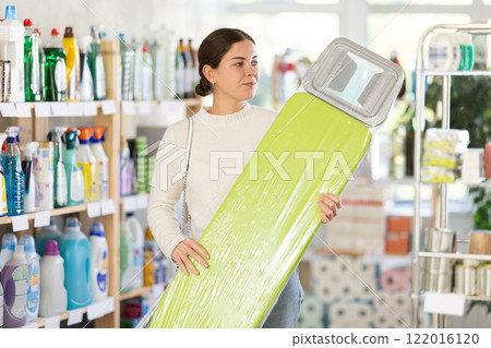 Woman choosing an ironing board 122016120