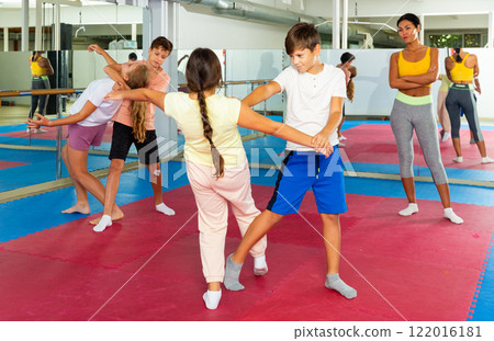Young boys and girls learning self-protection moves 122016181