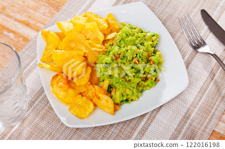 Plate of mexican chips with guacamole and glass beer closeup 122016198