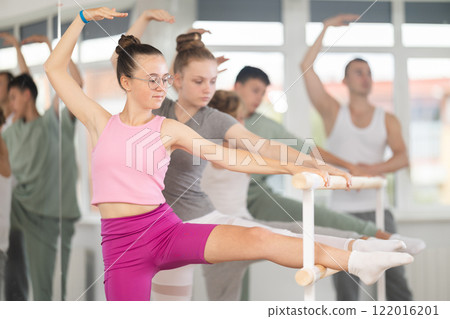 Teen ballet students prepare for classes, near ballet bare stretch legs under man teacher guidance 122016201