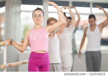 Teenage girl practicing ballet positions in dance studio 122016212