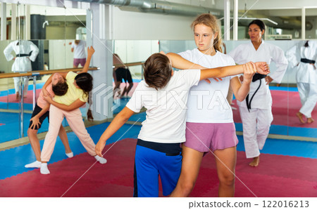 Young boys and girls learning self-protection moves 122016213