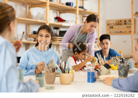 Preteen girl speaking to a circle member while processing ceramic items Preteen girl speaking to a circle member while processing ceramic items 122016282