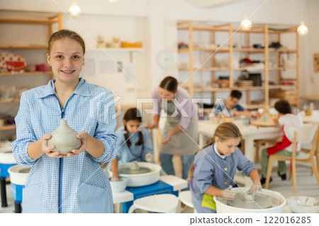 Teenage girl standing in art studio 122016285