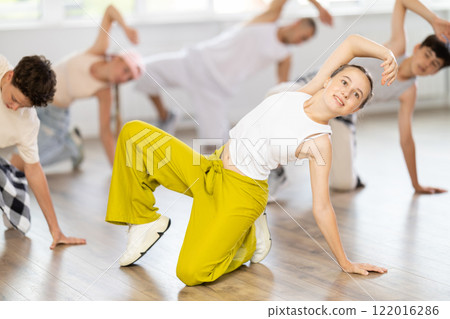Teenage girl dancing breakdancing in group Teenage girl dancing breakdancing in group 122016286