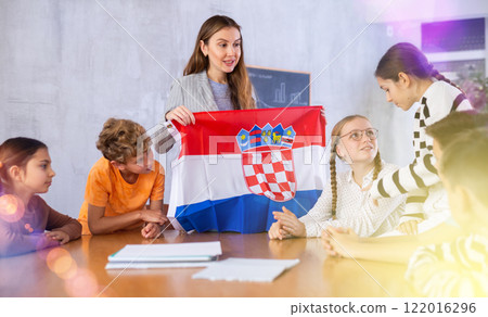 Female teacher working with students in school class, talking about national flag of Croatia at history lesson Female teacher working with students in school class, talking about national flag of Croatia at history lesson 122016296