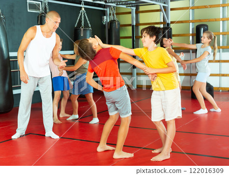Kids exercising chin strike in gym 122016309
