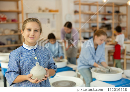 Little girl standing in art studio Little girl standing in art studio 122016318
