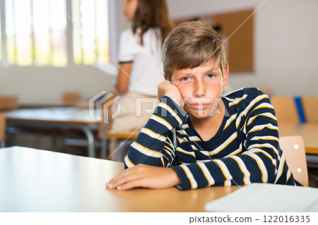 Portrait of bored schoolboy in classroom Portrait of bored schoolboy in classroom 122016335