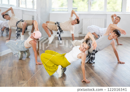 Teenage girl dancing breakdancing in group Teenage girl dancing breakdancing in group 122016341