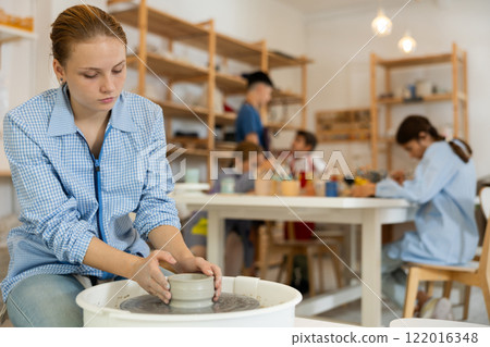 Teenage girl working at potter's wheel Teenage girl working at potter's wheel 122016348