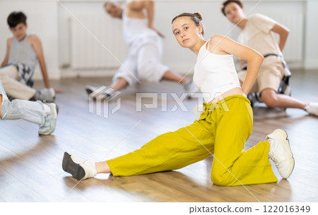 Group of young friends learn group dances - low break and breakdance in studio Group of young friends learn group dances - low break and breakdance in studio 122016349