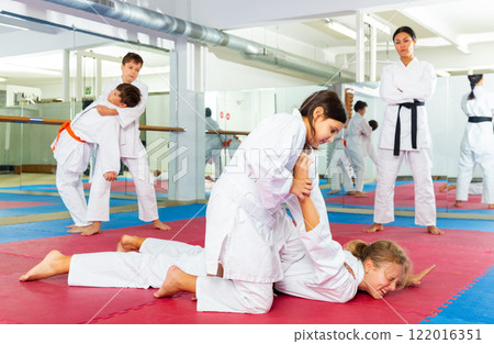 Teenager girls practicing karate in pairs 122016351