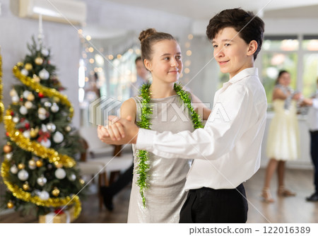 Smiling teenager dancing ballroom dance with girl during college Christmas party 122016389