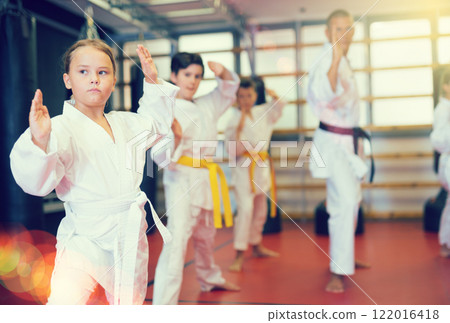 Karate kids in kimono performing kata moves 122016418
