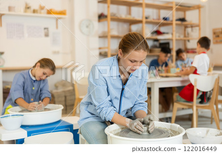 Teenage girl working at potter's wheel Teenage girl working at potter's wheel 122016449