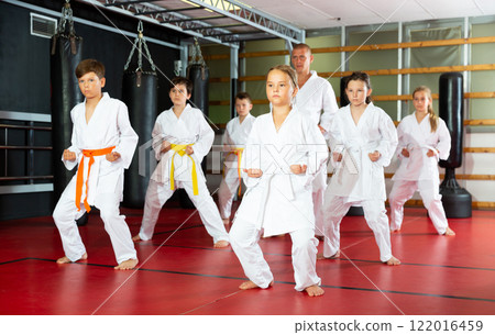 Schoolchilds practicing new technique in karate class Schoolchilds practicing new technique in karate class 122016459