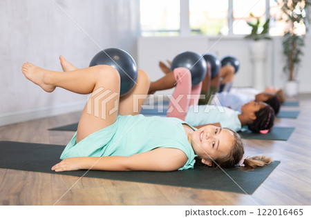 Group of multiethnic children doing pilates with soft ball 122016465