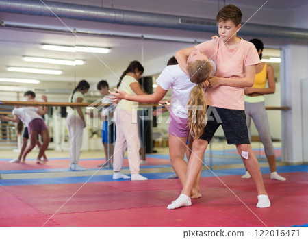 Group of kids training self-defence moves in gym 122016471