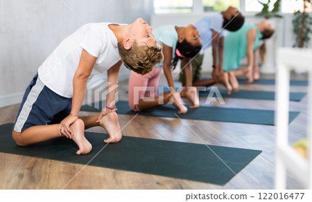 Young boy doing yoga in group of children 122016477