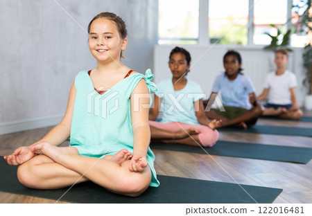 Training yoga kids on yoga mat in gym. Training yoga kids on yoga mat in gym. 122016481