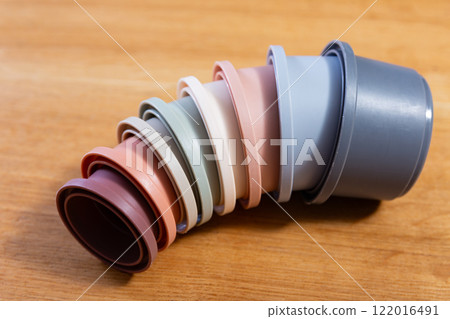 Plastic cups from disassembled pyramids scattered on wooden surface 122016491