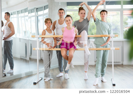 Portrait of group of teenagers together with choreography teacher during break between ballet lessons Portrait of group of teenagers together with choreography teacher during break between ballet lessons 122016504