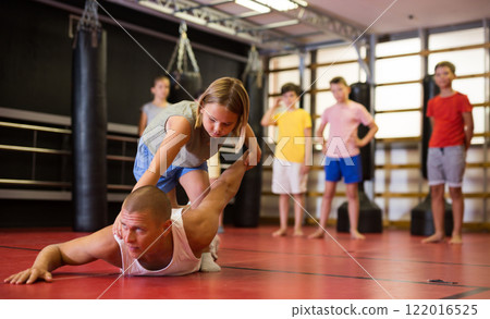 Girl training armlock move in gym 122016525
