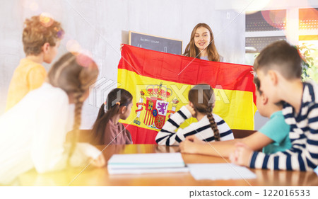 Teacher showing Spain flag to group of schoolchildren Teacher showing Spain flag to group of schoolchildren 122016533