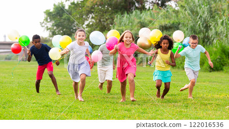Boys and girls with balloons running thruogh field Boys and girls with balloons running thruogh field 122016536