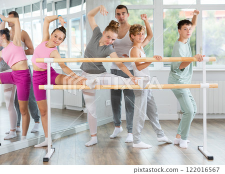 Ballet pose grand batman - girls and boys at a choreography lesson are learning ballet movements in studio 122016567