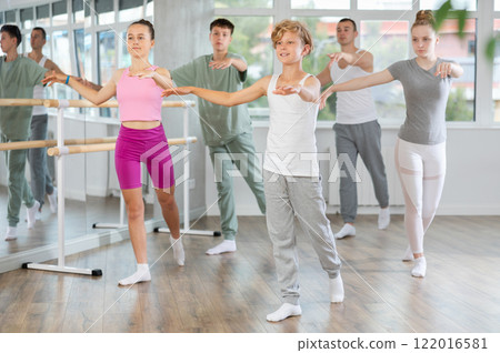Girls and boys are learning various dance and ballet movements in studio Girls and boys are learning various dance and ballet movements in studio 122016581