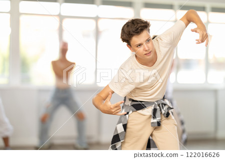 Teenage boy dancing hip-hop against background of group members 122016626
