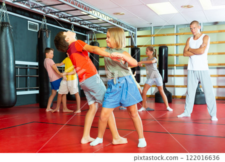 Children practicing self defence technique in pairs 122016636