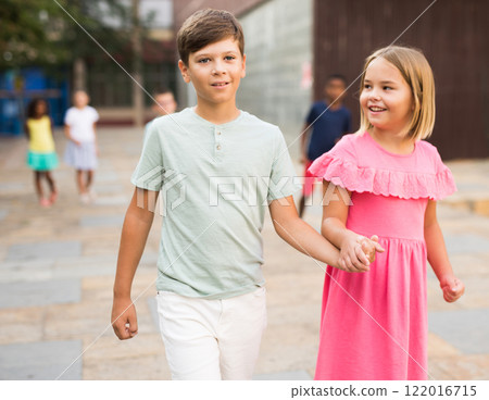 Happy tween girl and boy enjoying walk around city in summer 122016715