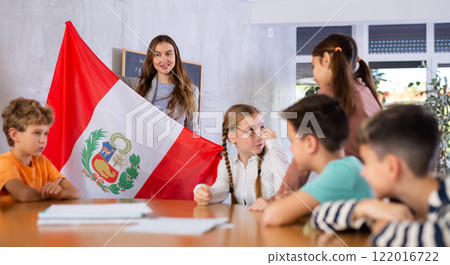 Teacher showing Peru flag to group of schoolchildren 122016722