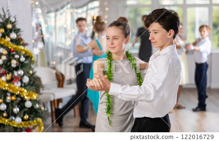 Couples dancing - teenagers in festive clothes dance the Viennese waltz near Christmas tree 122016729