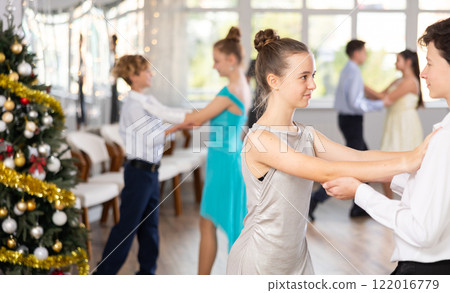 Teenage girl dancing ballroom dance with boy during New Year party 122016779