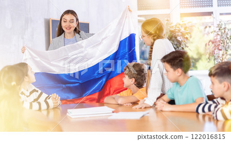 Teacher showing Russia flag to group of schoolchildren Teacher showing Russia flag to group of schoolchildren 122016815