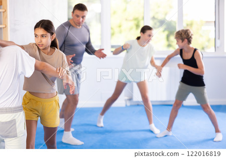 Boy and girl train to perform works out blow to jaw at opponent, while learning self-defense 122016819