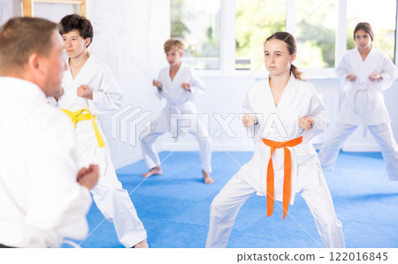 Children students repeat position and perform sequence of punches and painful techniques kata Children students repeat position and perform sequence of punches and painful techniques kata 122016845